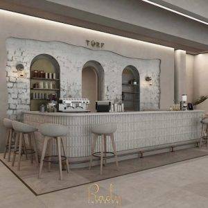 Luxury café interior design in Dubai featuring modern bar counter, arched niches, textured finishes, and warm ambient lighting by Rady Interior