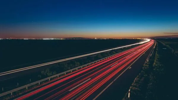 Long exposure image of nighttime highway traffic, showcasing light trails, designed by Rady Interior.